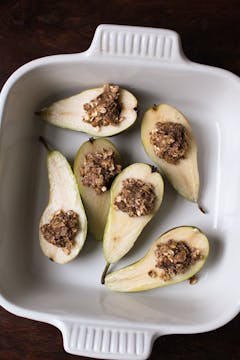 Pears filled with a crumble mixture in a baking dish