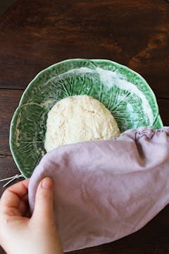 covering the dough in bowl with towel