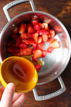 strawberry in saucepan and maple syrup being added