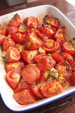 cooked tomatoes, garlic and herbs on baking tray