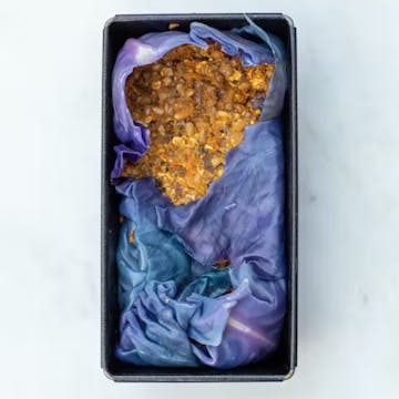 nut roast wrapped in a cabbage leaf in a baking tin
