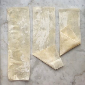A demonstration of filo pastry being folded for samosas.