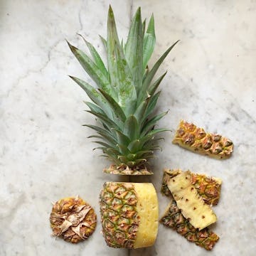 pineapple in the process of getting cut