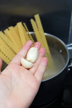 2 garlic cloves and pasta in boiling water