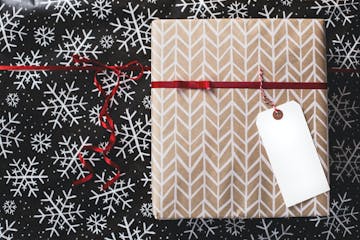 A wrapped Christmas present, with a red ribbon around it. There's an empty tag attached to it.
