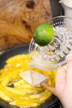 lemon juice being poured in pan