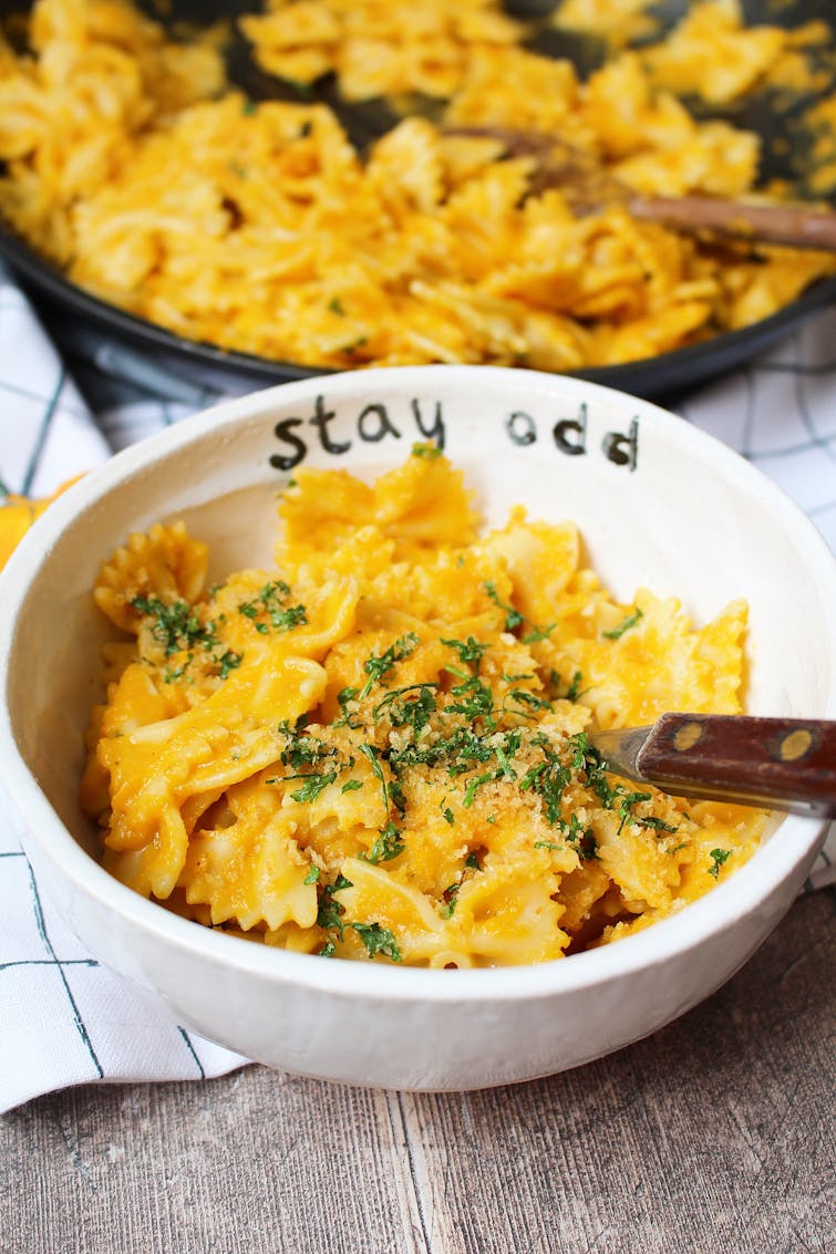 creamy carrot pasta served in bowl with parsley