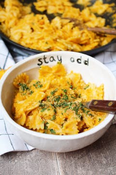 creamy carrot pasta served in bowl with parsley