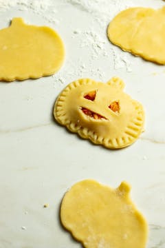 A filled butternut squash empanada, pressed on the sides with a fork. 