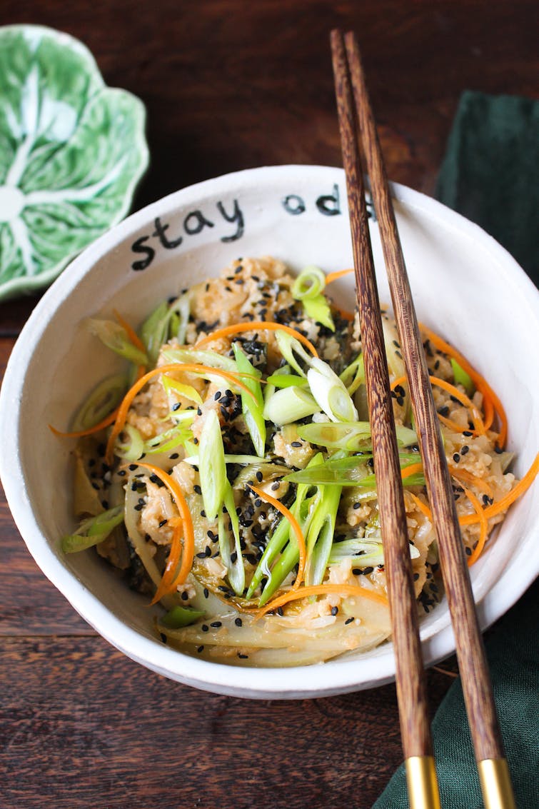 Sweet and sticky pak choi stir fry rice in a white bowl with chopsticks