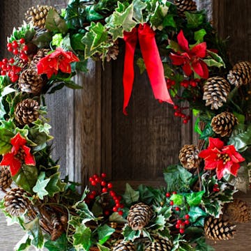 christmas wreath with red flowers and a bow