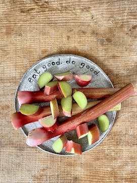 Rhubarb cut up on a plate on a wooden table