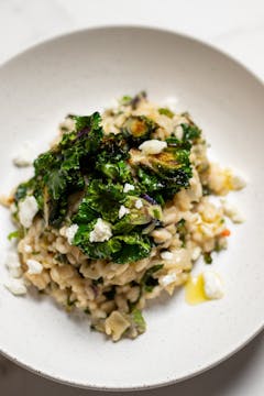 creamy kalettes served with creamy goats cheese on a white plate