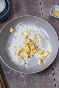 diced butter, self raising flour, salt and pepper in a mixing bowl 