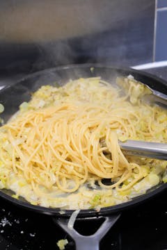 image of pasta being mixed with leek fondue
