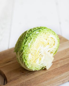 Half a head of cabbage on a chopping board.