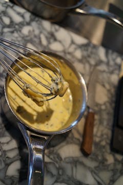 The blue cheese sauce being whisked together.