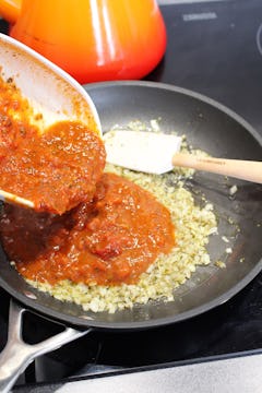 tomato sauce being added in the pan 