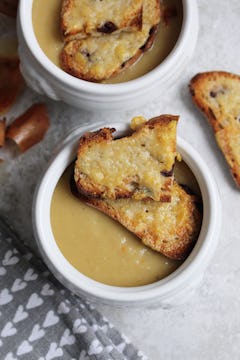 two dishes of old fashioned french onion soup topped with 2 slices cheese on toast