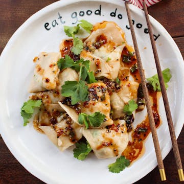 Kale and tofu wontons with wooden chopsticks on the side