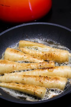 parsnips caramelising in a pan