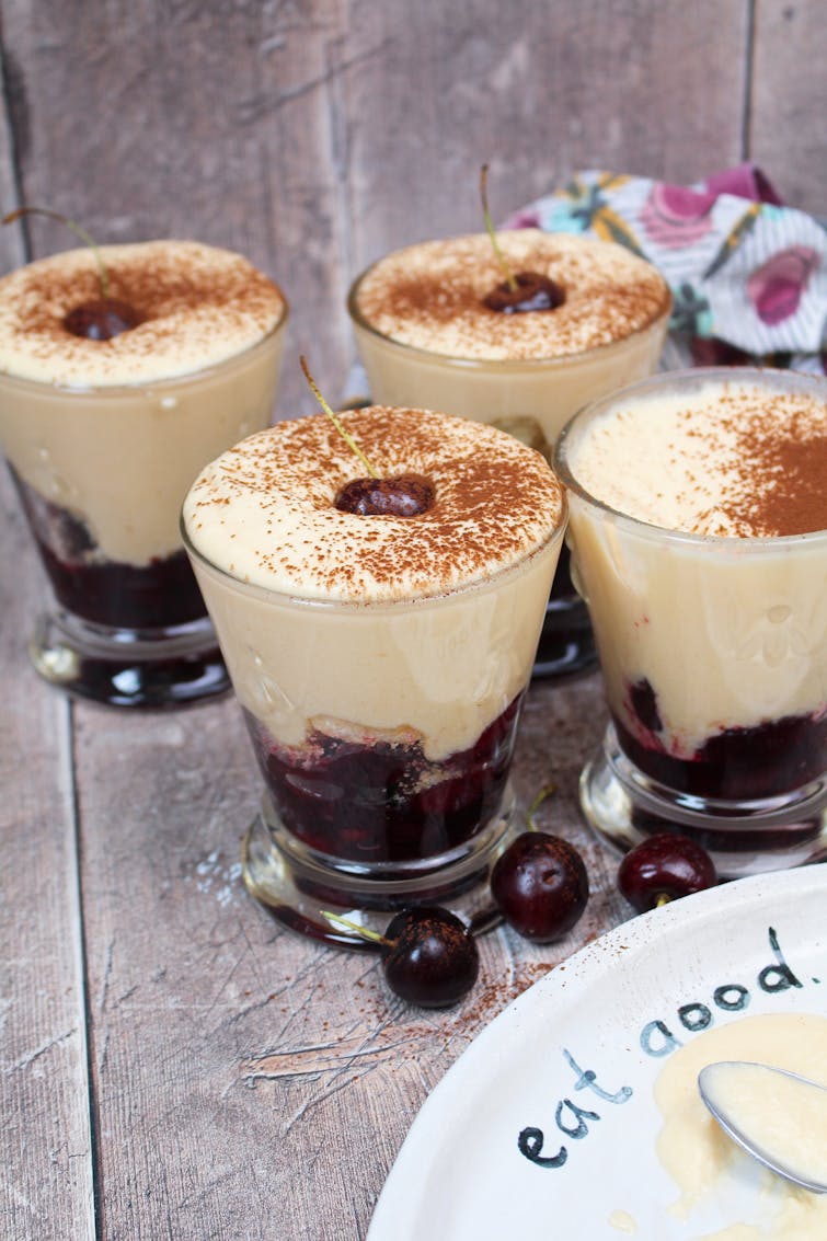 Fruity tiramisu topped with fresh cherry and cocoa powder  