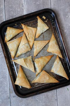 Baked filo parcels in an oven tray.