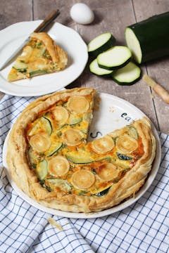 baked courgette and goat cheese quiche served on a pizza