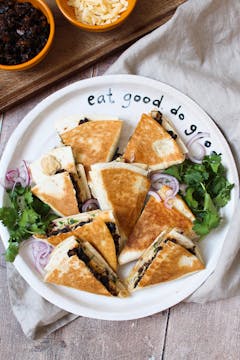 A plate of mushroom tortilla wraps, cut into small triangles. 
