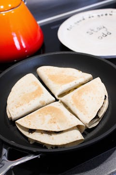 The tortilla wraps being fried in a pan. 