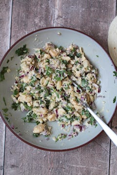 A bowl of mashed butter beans, coriander, and red onion. 