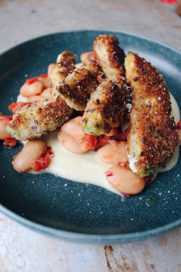 image of Baked breaded avocado fries, tomato and red onion compote, spiced parsnip purée