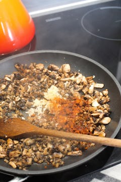 Mushrooms frying in a pan.