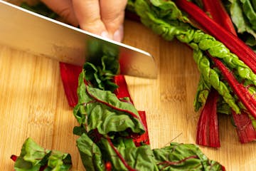 Chard leaves being cut into inch-long pieces.