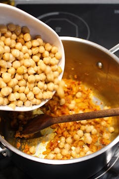 image of chickpeas being added to pan