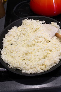 grated cauliflower getting toasted in a pan