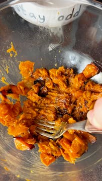 roasted butternut squash being mashed with a fork