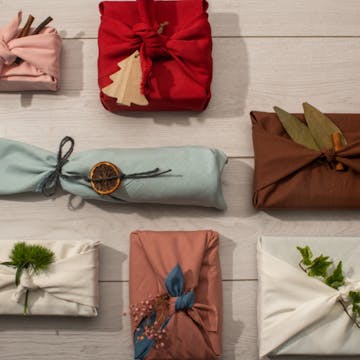 Christmas presents wrapped in cloth with leaves to decorate