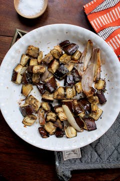 roasted aubergine and shallots with seasoning in a white bowl