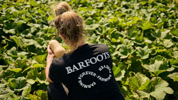 woman harvesting butternut squash in a black tshirt