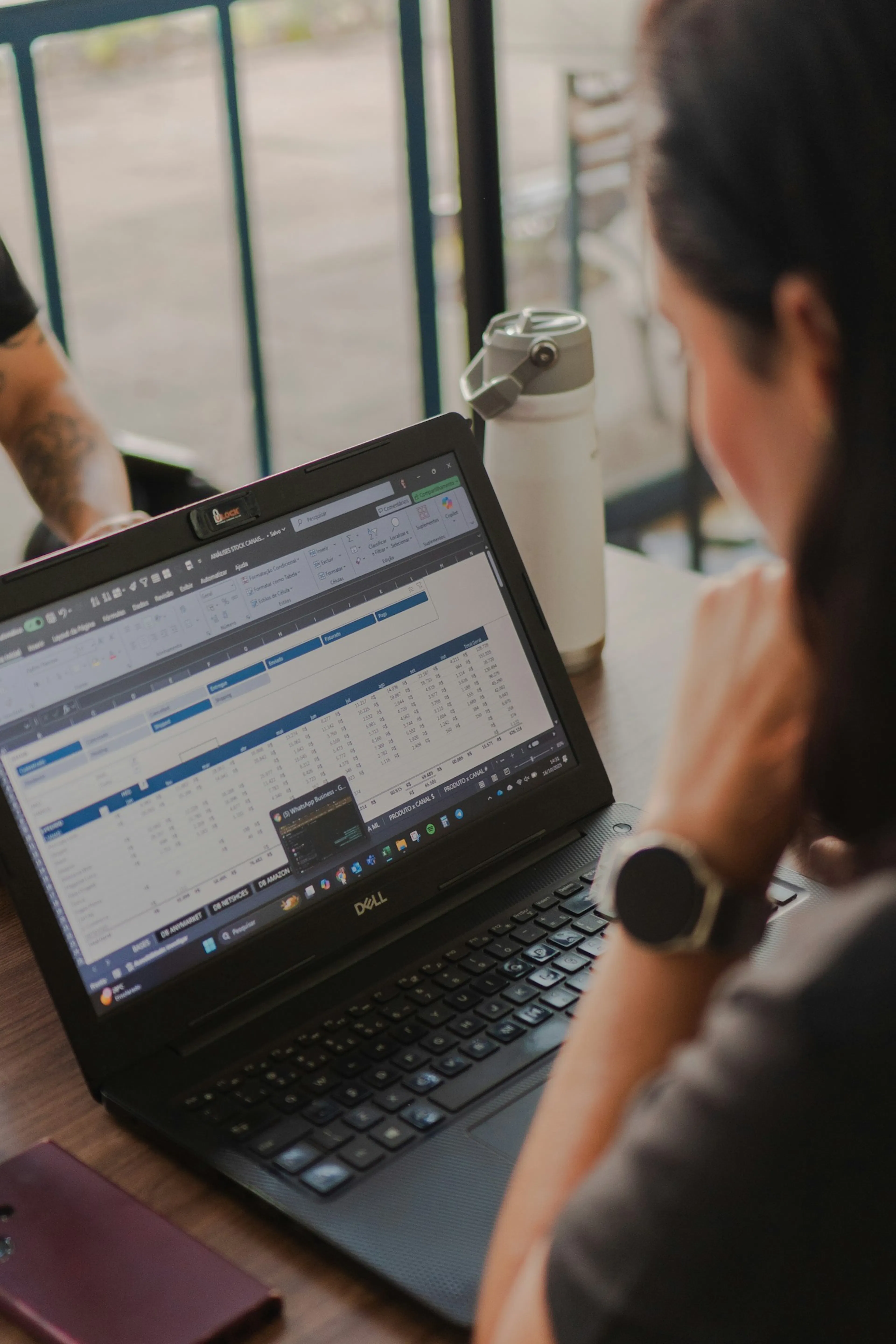 A person working through spreadsheet data on a laptop