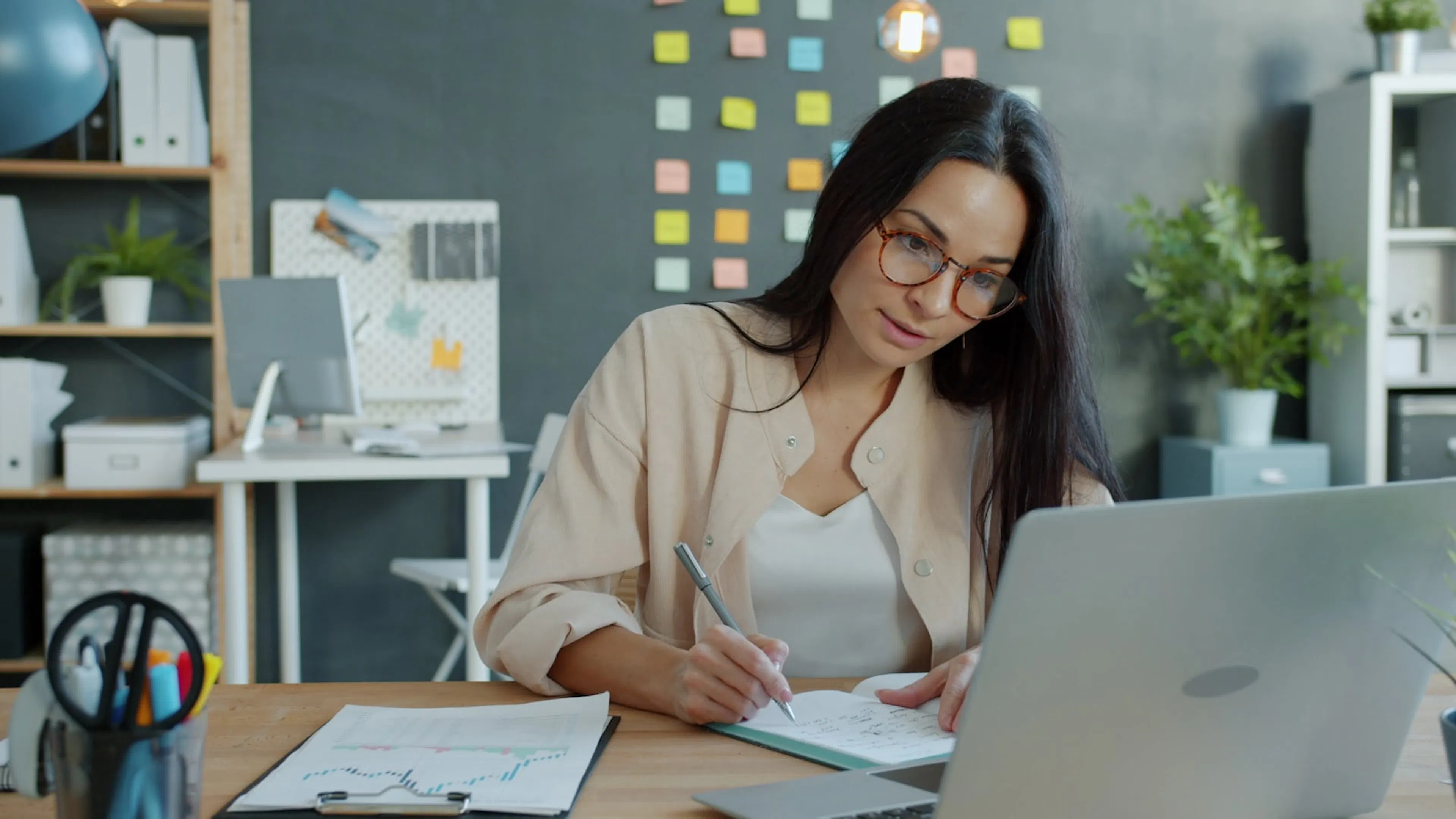 A letting agent working at a desk with a laptop and notebook