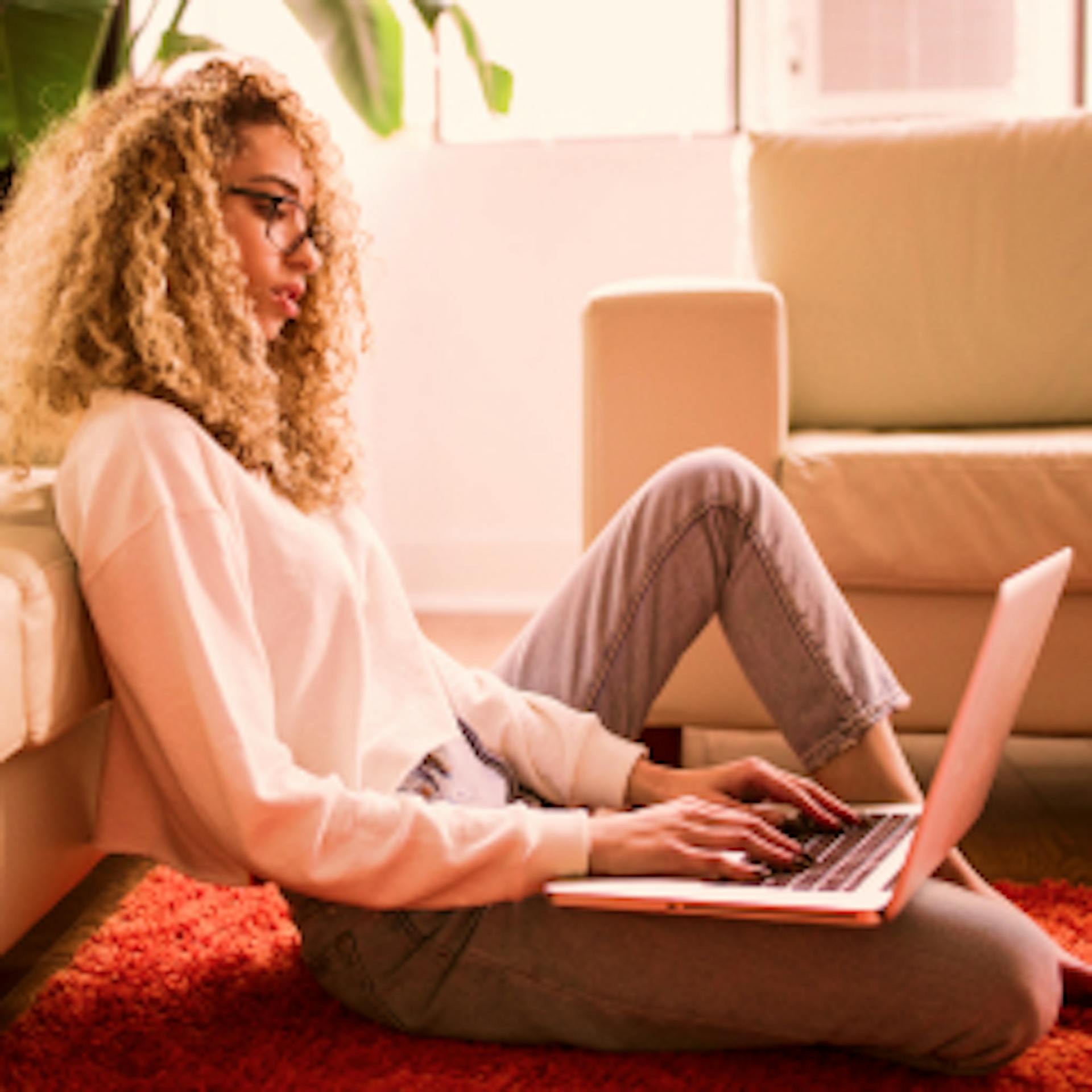 Fotografia de uma mulher sentada mexendo em um Notebook