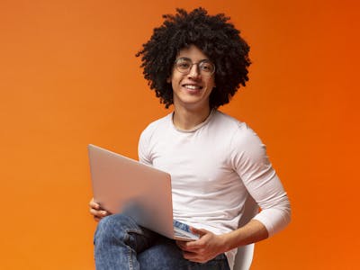 Garoto com notebook no colo utilizando Internet Oi.