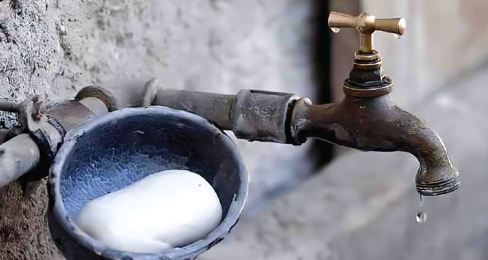 Soap in pot beside old outdoor tap