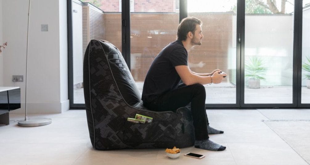 Man gaming on chair shaped beanbag