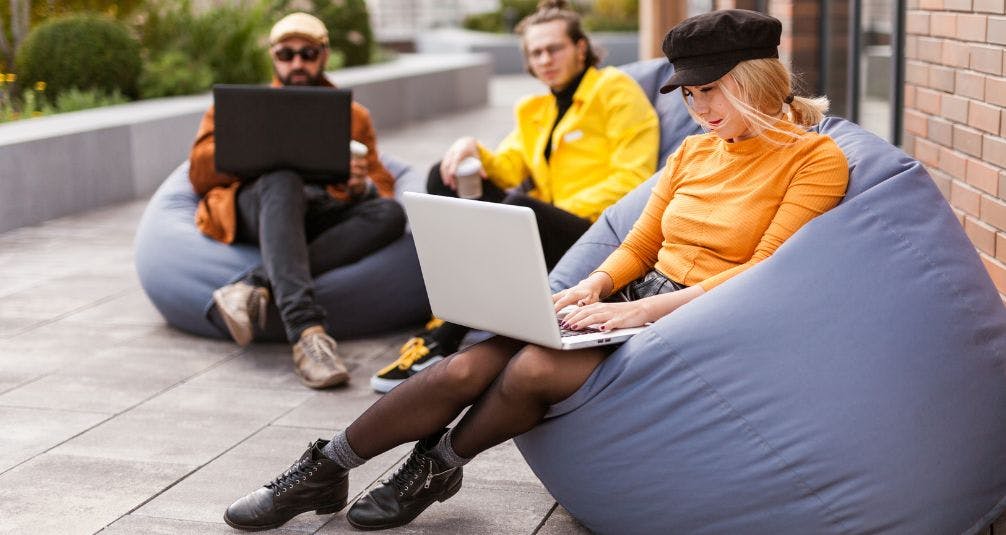 People using laptops wile sitting on beanbags