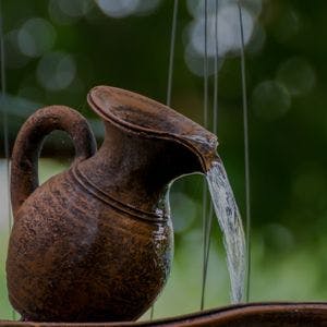 Jug Antique Metal Water Feature with water pouring out close up