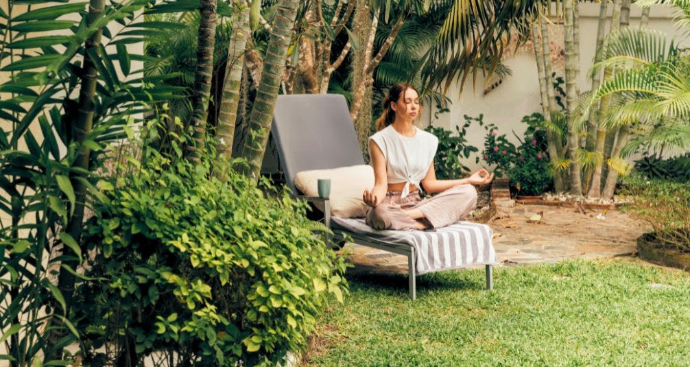  meditating in garden on sun lounger