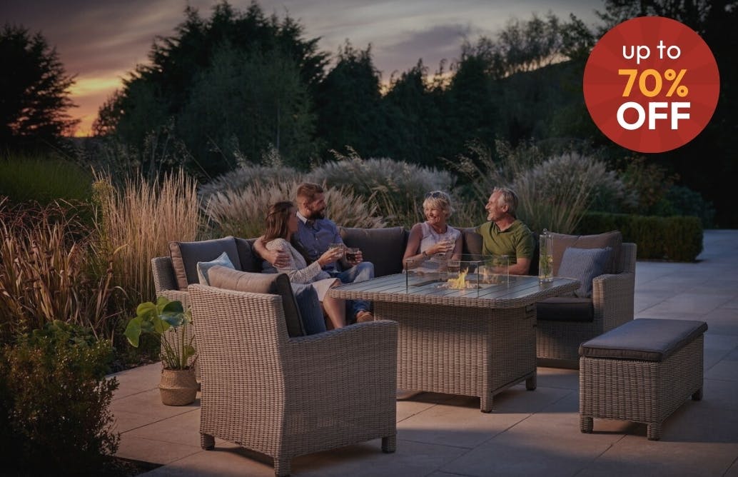 Family Enjoying Garden Around Fire Pit Dining Table